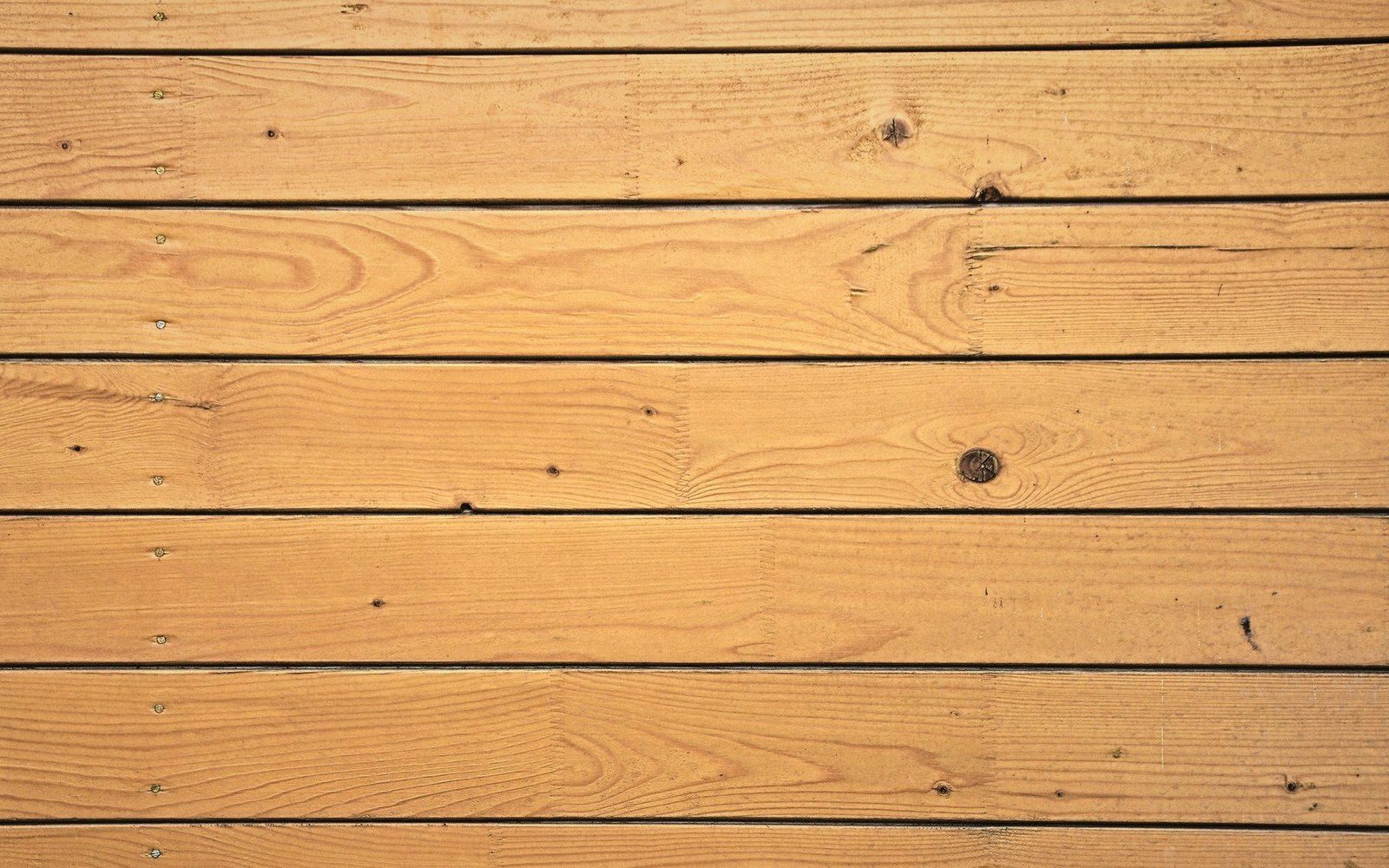 Horizontal wooden deck boards with visible knots and screw fasteners