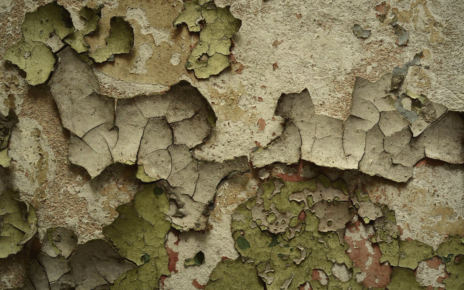 Cracked and peeling paint layers reveal patches of green and rust-colored underlayers beneath