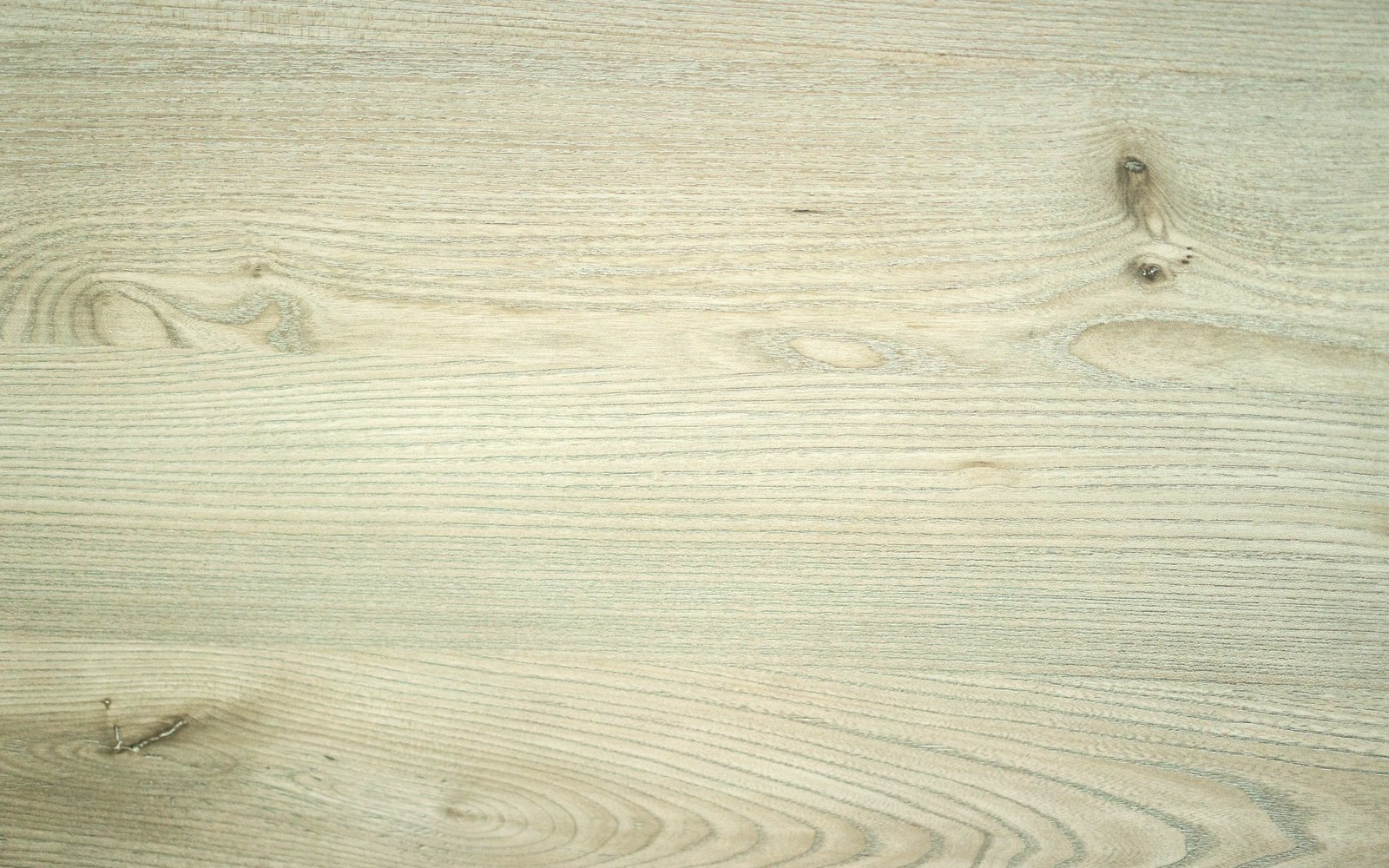 Close-up of pale oak wood grain with visible knots and swirling growth rings