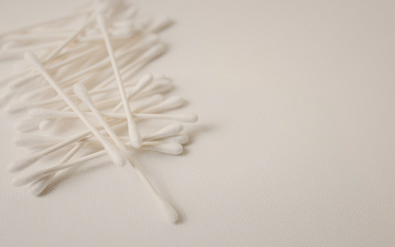A cotton swab and a small dish of solvent on a bench